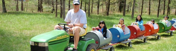 kids on a train being pulled by a John Deere trractor